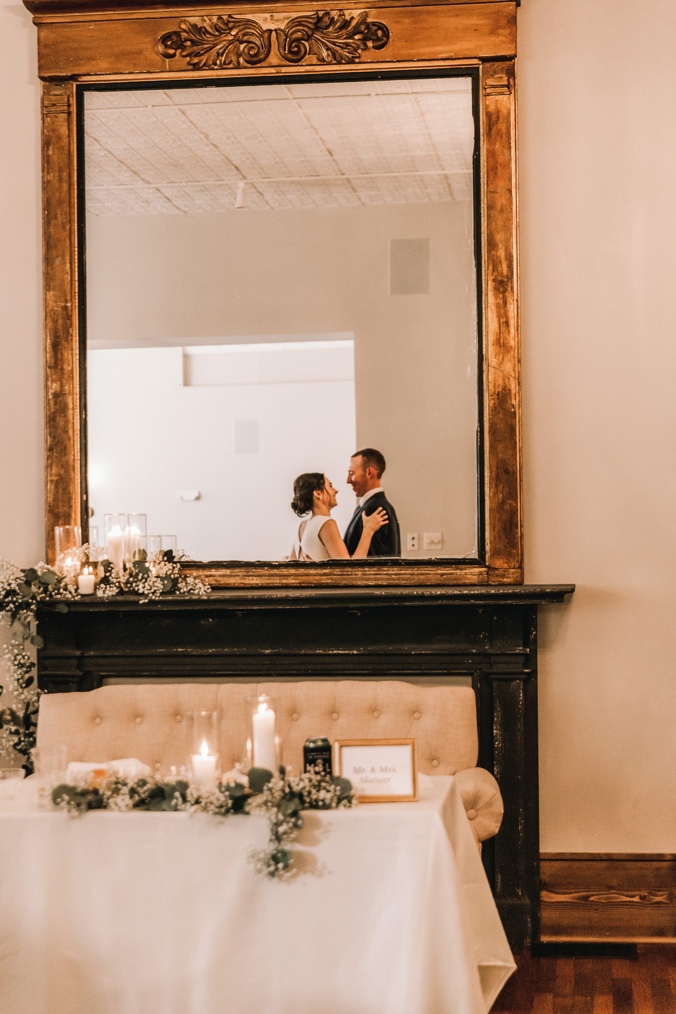 Bride and groom's reflection in mirror at Kansas wedding venue.
