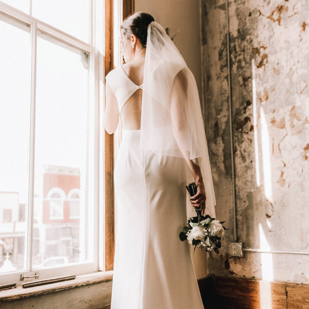 Bride reflects on day looking out of large window