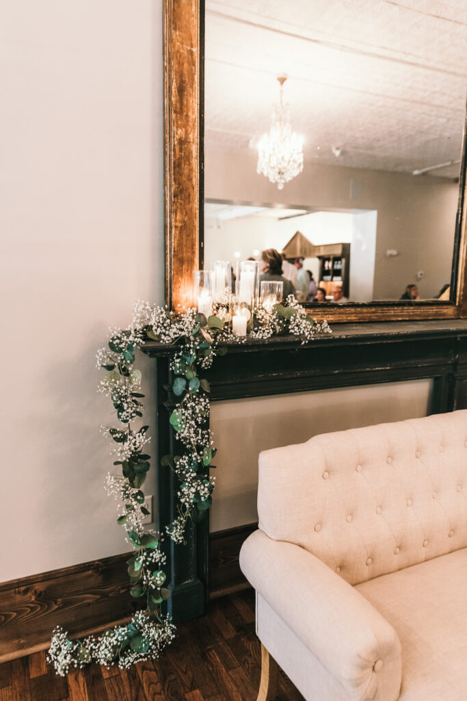 greenery and baby's breath adorn historic mantle and mirror at Kansas wedding venue